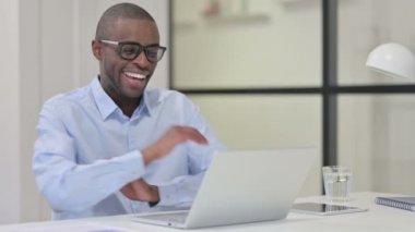 Dizüstü bilgisayarda konuşan Afrikalı adam. 