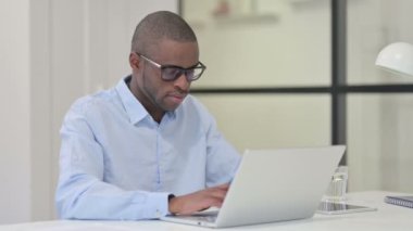 Dizüstü bilgisayarlı Afrikalı Kameraya gülümsüyor 