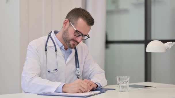 Medicul de sex masculin scrie pe hârtie în spital — Videoclip de stoc