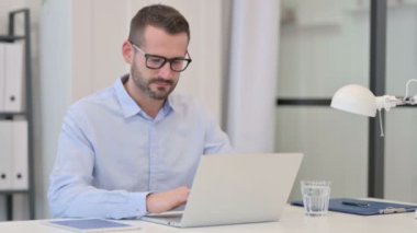 Orta yaşlı adam dizüstü bilgisayarda çalışırken şok olmuş hissediyor 