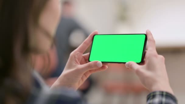 그린 크로마키 스크린으로 스마트폰을 보고 있는 여성 — 비디오