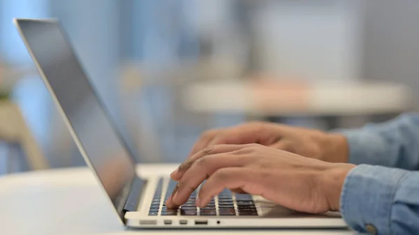 Mani di uomo africano digitando sulla tastiera del computer portatile, Primo piano — Foto Stock