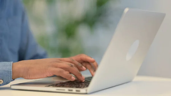 Hands of African Man Typing on Laptop Keyboard, Close Up