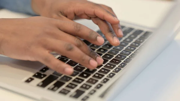 Hands of African Man Typing on Laptop Keypad, Close Up