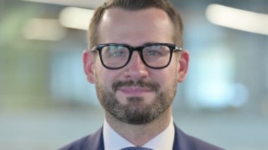 Orta yaşlı iş adamının yakın çekimi Kameraya gülümsüyor 