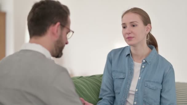 Gelukkige vrouw in gesprek met man op de bank — Stockvideo