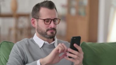 Koltukta Smartphone kullanan Orta yaşlı bir adamın portresi 