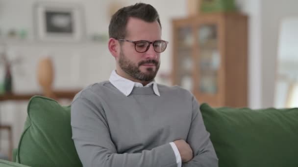 Hombre de mediana edad sintiéndose preocupado mientras piensa en el sofá — Vídeos de Stock