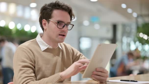 Mladý muž v kanceláři slaví úspěch na tabletu — Stock video