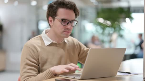 Młody mężczyzna projektant z laptopem pokazując kciuki w górę Zarejestruj — Wideo stockowe