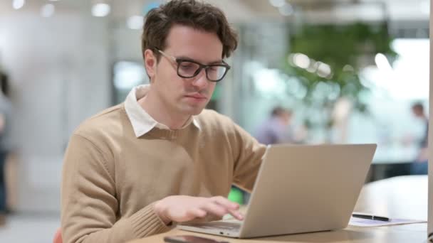 Diseñador masculino joven que muestra ningún signo mientras trabaja en el ordenador portátil — Vídeo de stock
