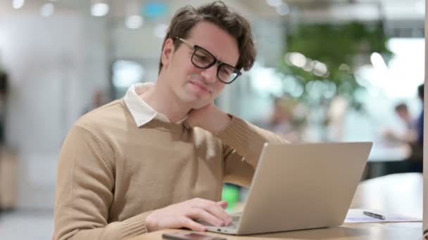 Homem com dor no pescoço enquanto trabalhava no laptop — Vídeo de Stock