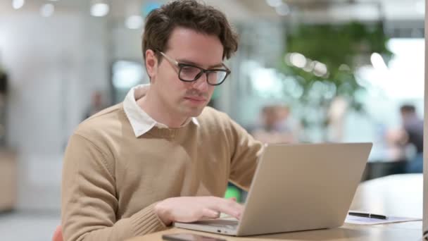 Giovane Designer maschile con computer portatile con mal di schiena in ufficio — Video Stock