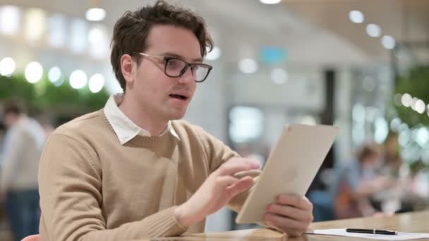 Appel vidéo sur tablette par l'homme au bureau — Video