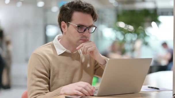 Ocupado homem pensando enquanto trabalhava no laptop no escritório — Vídeo de Stock