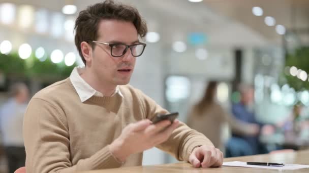 Ung Man Designer Prata på Smartphone, i Office — Stockvideo