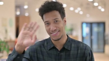 Afro-Amerikalı adam el sallıyor. Hoş geldiniz.