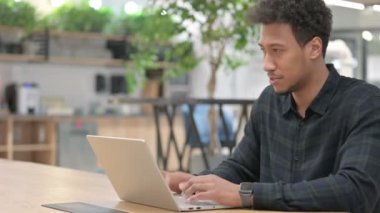 Ofiste dizüstü bilgisayarda çalışan Afrikalı Amerikalı adam. 