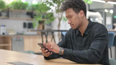 İş yerinde akıllı telefon kullanan çekici Afrikalı Amerikalı. 
