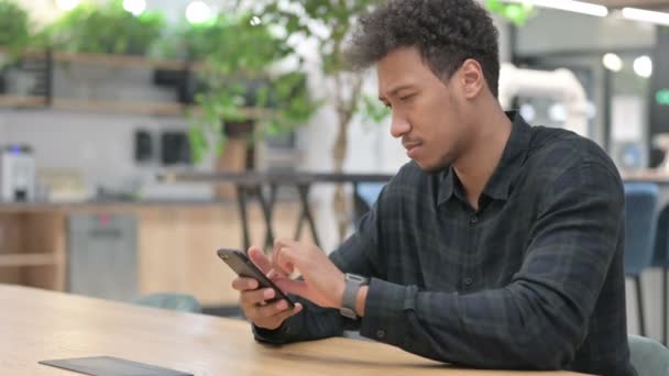 Attraente uomo afroamericano che utilizza Smartphone al lavoro — Video Stock