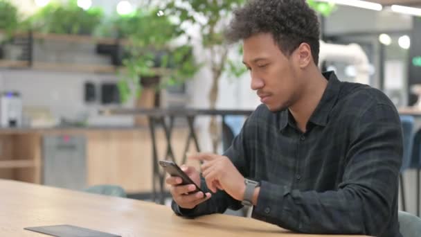 Hombre afroamericano celebrando mientras usa Smartphone — Vídeo de stock