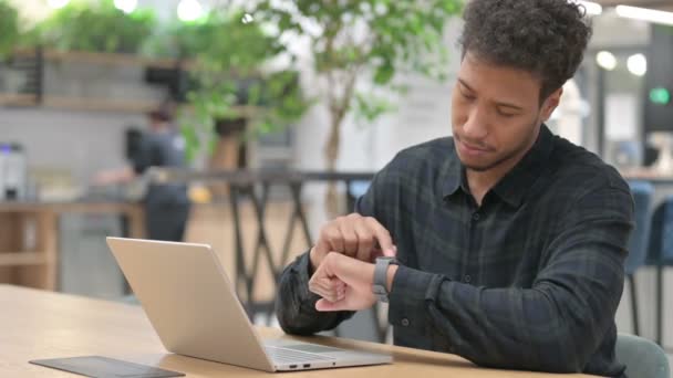 Afrika Amerika Man dengan Laptop Memeriksa Smart Watch — Stok Video