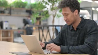 Dizüstü bilgisayarlı Afrikalı Amerikalı Adam 'dan Başparmak İndirme İşareti 