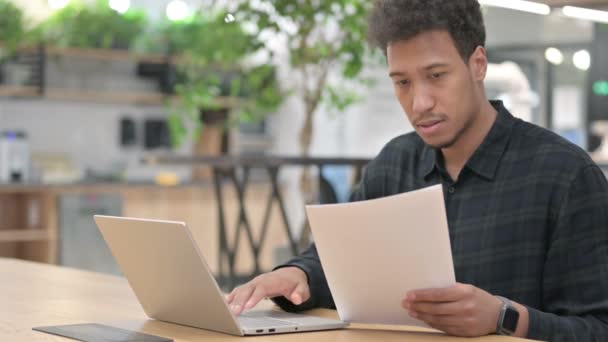 Afro-Américain avec ordinateur portable lecture de documents — Video