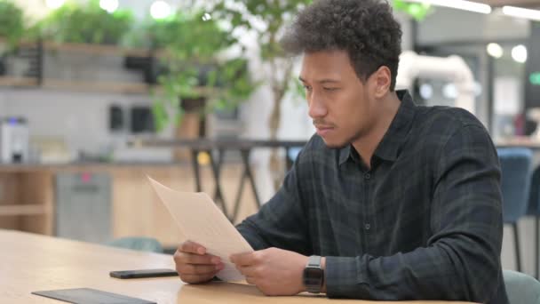 Hombre afroamericano que tiene éxito mientras lee documentos — Vídeos de Stock