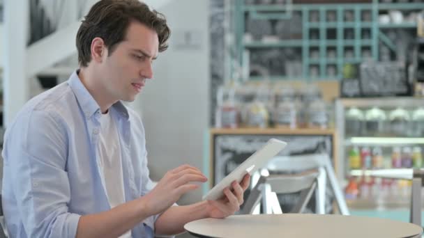 Jovem bem sucedido comemorando no tablet no café — Vídeo de Stock