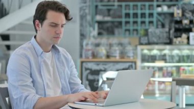 Cafe 'de laptopta çalışan genç adam. 