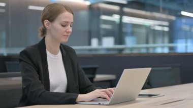 İş kadını dizüstü bilgisayar kullanırken Başparmaklarını Aşağı Gösteriyor