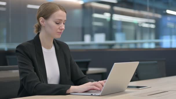 Businesswoman Při pohledu na fotoaparát při práci na notebooku — Stock video