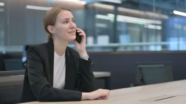 İş kadını iş yerinde Smartphone ile konuşuyor 