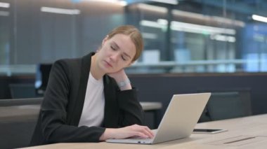 İş kadını dizüstü bilgisayarda yazarken boyun ağrısı çekiyor 