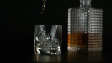 Buzlu Alkolün Yavaş Hareketi, Siyah Arkaplanda Viski Şişesi 