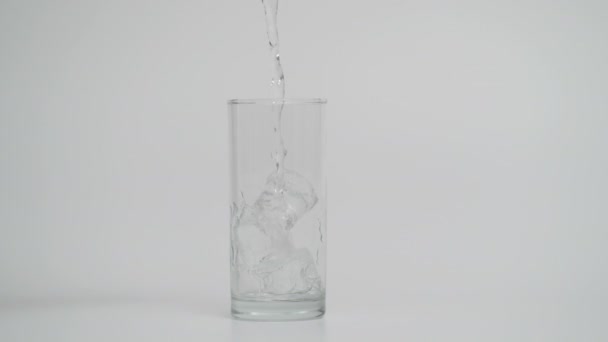 Mouvement super lent de verser de l'eau dans le verre avec de la glace, 1000 images par seconde — Video
