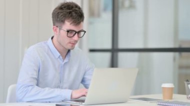 Ofisinde dizüstü bilgisayarı olan Genç Adam 'dan Başparmak İndirme 