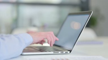 Dizüstü bilgisayarda yazan genç adama yaklaş. 