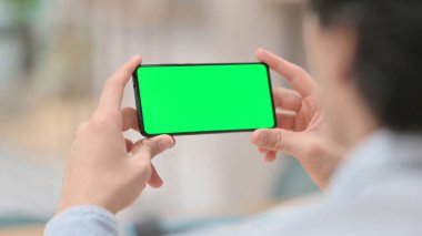 Yeşil Krom Anahtar Ekranlı Akıllı Telefon İzleyen Adam