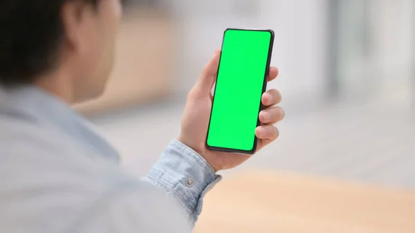 Vista posteriore, Man Holding Smartphone con schermo chiave cromato verde — Foto Stock