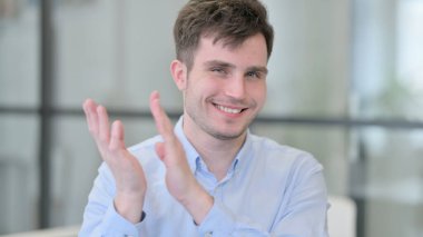 Genç adam alkışlıyor, takımı alkışlıyor.