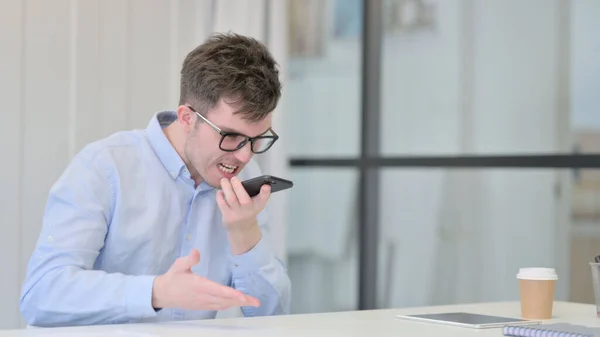 Irritado Jovem Falando no telefone no escritório — Fotografia de Stock