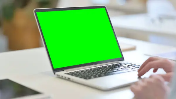 Giovane uomo che utilizza il computer portatile con schermo cromato verde — Foto Stock