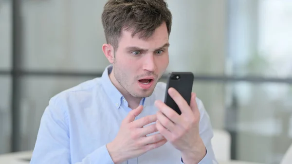 Fiatal férfi elvesztése portré okostelefonon — Stock Fotó