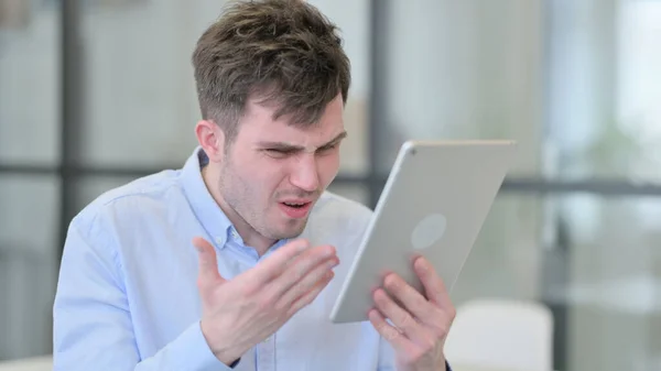 Jeune homme réagissant à la perte sur tablette — Photo