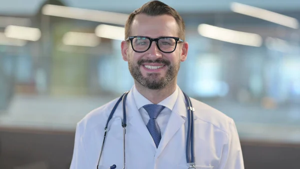Portret van een jonge mannelijke arts glimlachend bij de camera — Stockfoto