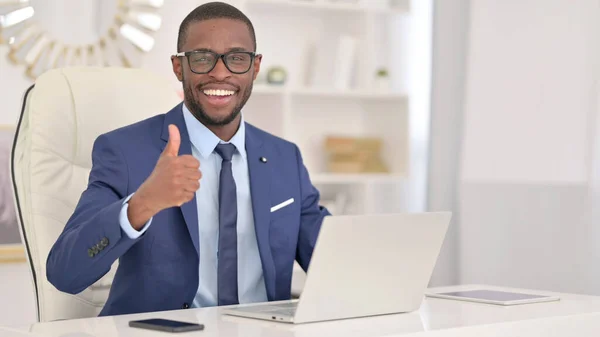 Empresário Africano positivo com laptop mostrando polegares para cima — Fotografia de Stock