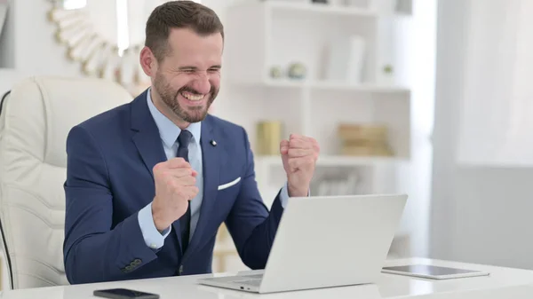 Homme d'affaires excité célébrant le succès sur ordinateur portable au bureau — Photo