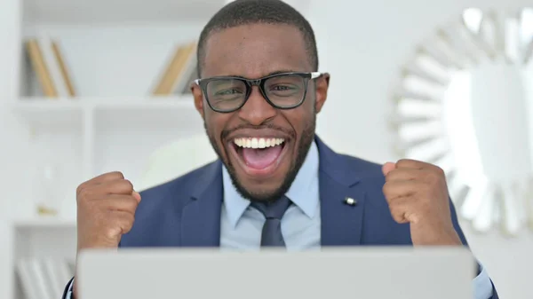 Porträtt av afrikansk affärsman firar framgång på laptop — Stockfoto